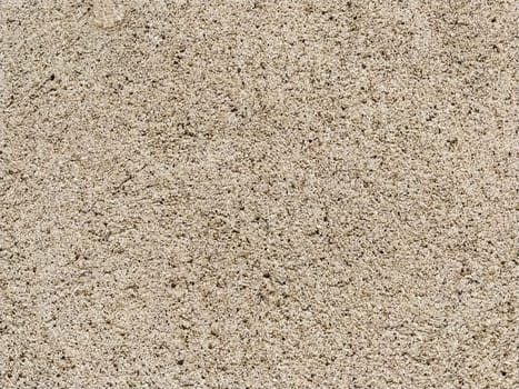 Concrete surface with multi-colored blotches of small stones. Light beige tone. Wall of a building or concrete slab. Close-up. Pockmarked cement surface. Interior or exterior finish option