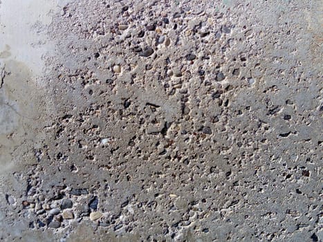Concrete wall with concentric damage of large radius. Potholes, tubercles and defects. Gray, brown and beige colors. Planet surface concept. Concrete wall with a worn surface, potholes and stones