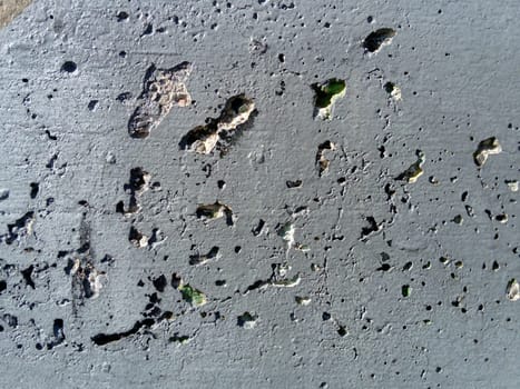 Concrete wall with concentric damage of large radius. Potholes, tubercles and defects. Grey colour. Planet surface concept. Concrete wall with a worn surface, potholes, bulges and small spots