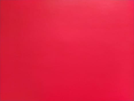 abstract red background or Christmas paper texture. Red base for cards for Valentine's Day, New Year, or Christmas. Color gradient.