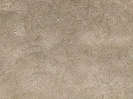 Concrete surface with multi-colored blotches of small stones. Light beige tone. Wall of a building or concrete slab. Close-up. Pockmarked cement surface. Interior or exterior finish option