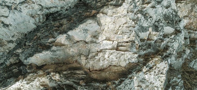 stone rock closeup in Sarajevo, Bosnia and Herzegovina. Ancient frozen lava. Layers and layers of minerals and rocks. Texture stone. Gray, green and beige colors