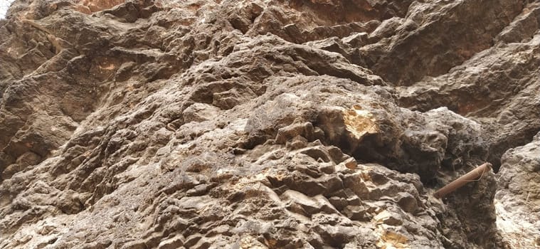 stone rock closeup. Sarajevo, Bosnia and Herzegovina. Ancient frozen lava. Layers and strata of rocks. Mountain after a guided explosion to lay the road. Texture of the stone. Gray and beige colors