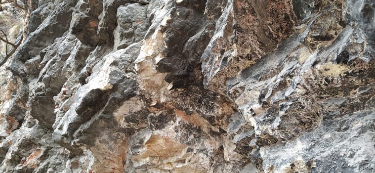 stone rock closeup in Sarajevo, Bosnia and Herzegovina. Ancient frozen lava. Layers and strata of rocks. Mountain after a guided explosion to lay the road. Texture of the stone. Gray and beige colors