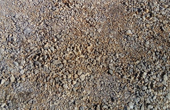 gray street small pebbles. Natural soil. Tiny different sizes and shades. Background with stone texture. Gray, brown, beige, black elements