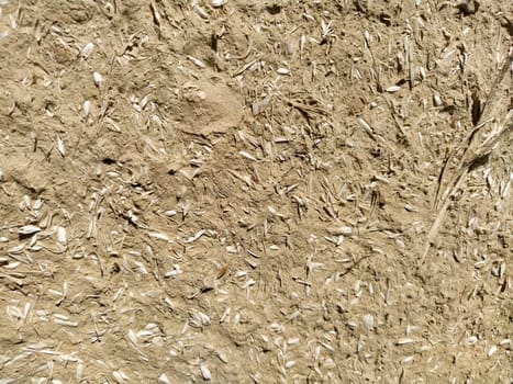 Close-up background of the wall of an old house made of clay mixed with straw. Old type of construction. Clay wall of straw and mud. Manure mixed with clay and dried as building material.
