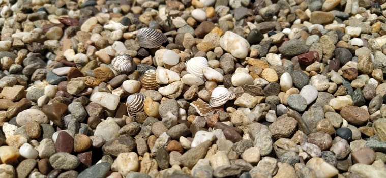 assorted colorful and smooth pebbles from the beach. Banner. Small and large gravel. Natural background.
