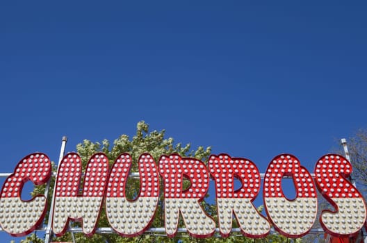 Churros fair stall banner. Blue sky background