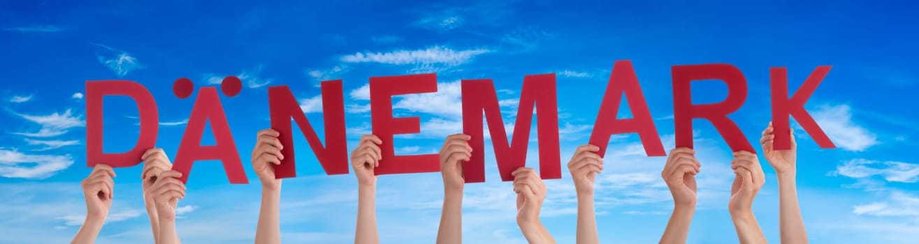 People Or Persons Hands Building German Word Daenemark Means Denmark. Blue Sky As Background.