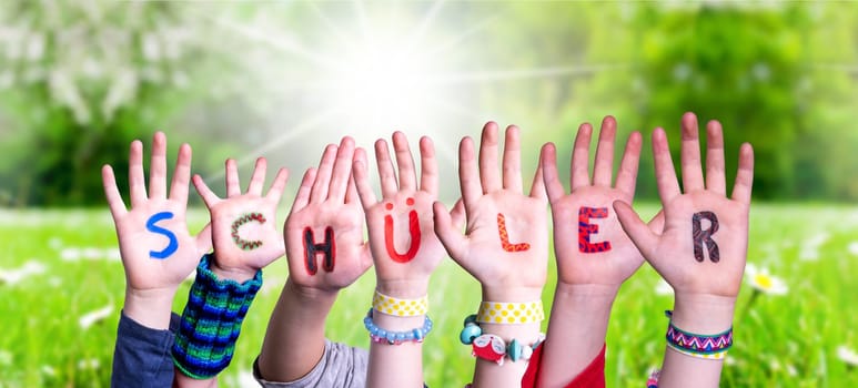 Children Hands Building Colorful German Word Schueler Means Pupil. Sunny Green Grass Meadow As Background.