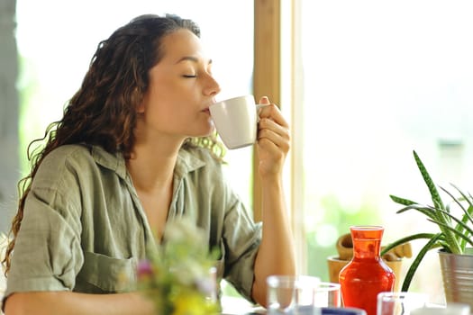 Woman drinking coffee sitting in a restaurant