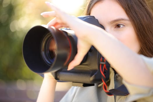 Photographer taking photos adjusting focus manually in a park