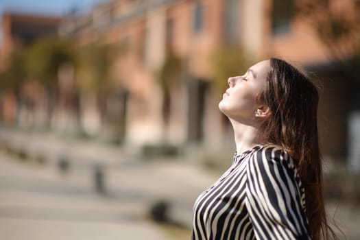 Profile of a woman breathing fresh air a sunny day in a residential area