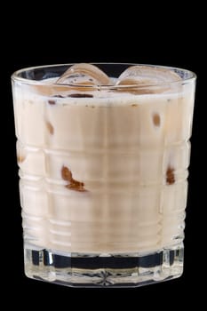 Cocktail white russian in facetted glass on black background