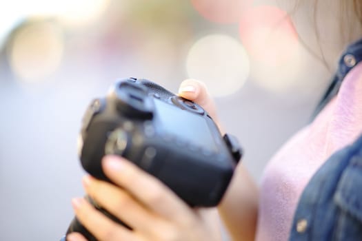 Close up of a photographer hand setting camera in the street