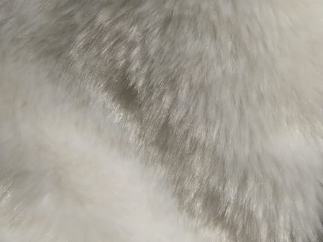 White faux fur. Close-up. Partially defocused photo. Fluffy villi.