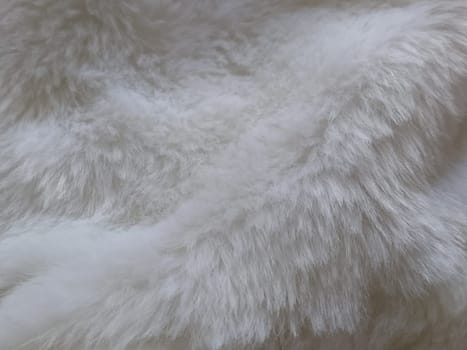 White faux fur. Close-up. Partially defocused photo. Fluffy villi.