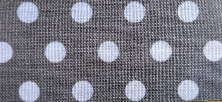 fabric white polka dots on a gray background, smoothed flat surface.