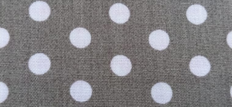 fabric white polka dots on a gray background, smoothed flat surface.