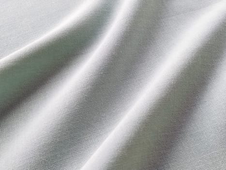 Beautifully folded fabric. Soft pleasant waves and flounces on textiles. Close-up. Drapery for curtains, fabric for dressmaking or upholstery. Black and white monochrome image