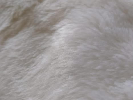 White faux fur. Close-up. Partially defocused photo. Fluffy villi.