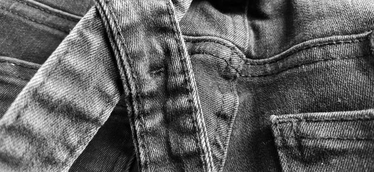 Fashionable denim clothing. Details and seams on rough denim. Black and white photography.
