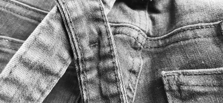 Fashionable denim clothing. Details and seams on rough denim. Black and white photography.