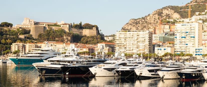 Monte Carlo, Monaco - August 2022: Port Hercule with luxury yachts,  boats, and scenery skyline