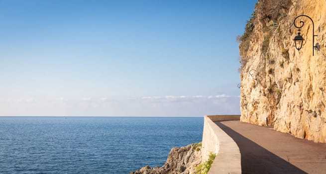Promenade in front of the sea. Blue sky on scenery seascape. Concept of travel, adventure, freedom
