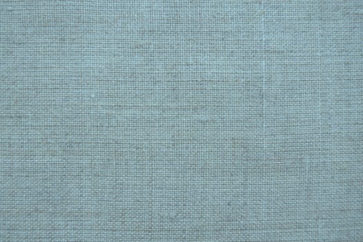 Fabric texture background. Blue fabric with weave. Natural slightly wrinkled look of the material. Uniform copy space background. Cotton, canvas or woolen thin fabric laid evenly on the surface