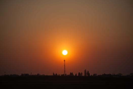Red sunset over the field. Beautiful sunset in nature. Rural nature at sunset. Red sunset landscape