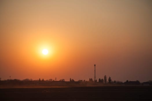 Red sunset over the field. Beautiful sunset in nature. Rural nature at sunset. Red sunset landscape
