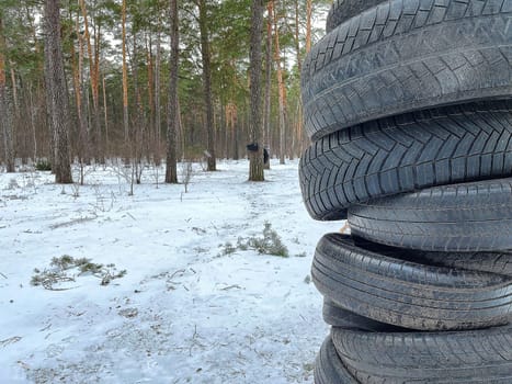 used tires on the background of a winter forest are adapted for athletes' training