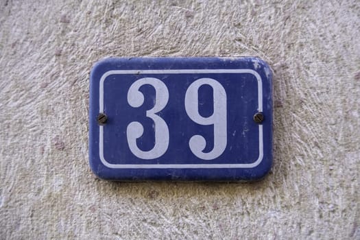 Detail of old odd number of information on a street in a town, address