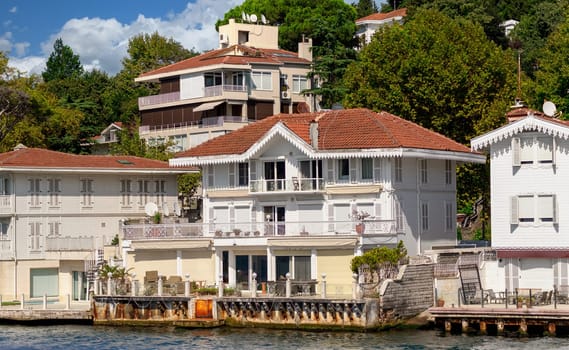 View from Bosphorus strait of the green mountains of the Asian side, with traditional houses and dense trees in a summer day, Istanbul, Turkey