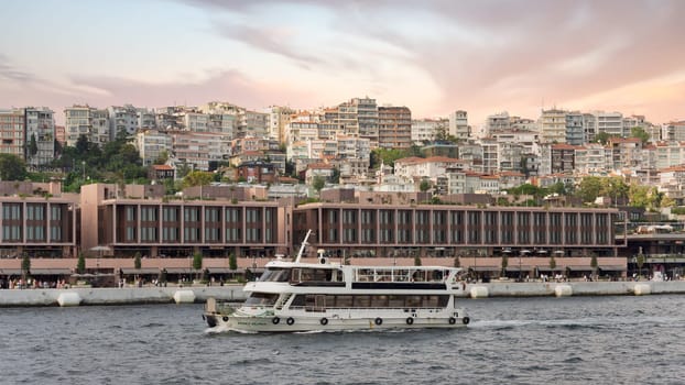 Istanbul, Turkey - September 1, 2022: Ferry boat sailing in Bosphorus Strait in front of Galataport, a mixed use development located in Karakoy neighbourhood