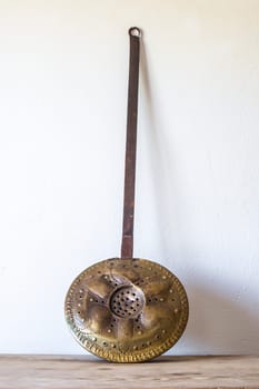 Old metal bed warmer. Country style background