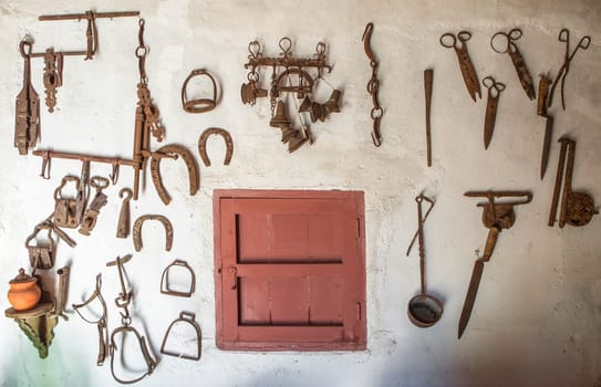 Old farm tools hanging on a wall. Country style background