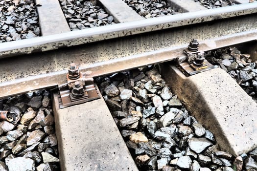 Railways. Metal steel rails and wooden sleepers. Rivets and fasteners on the railroad. Stony backfill of railway tracks. Station Nyrki, Karelia
