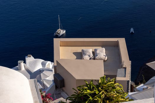 Oia, Santorini, Greece - June 28, 2021: Whitewashed houses with terraces and pools and a beautiful view in Oia on Santorini island, Greece