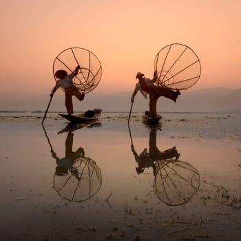 Fishermen at sunrise in the Landscape on the Inle Lake in the Shan State in the east of Myanmar in Southeastasia.