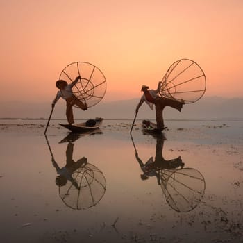 Fishermen at sunrise in the Landscape on the Inle Lake in the Shan State in the east of Myanmar in Southeastasia.