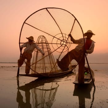 Fishermen at sunrise in the Landscape on the Inle Lake in the Shan State in the east of Myanmar in Southeastasia.