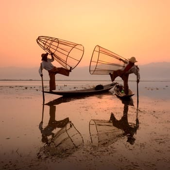 Fishermen at sunrise in the Landscape on the Inle Lake in the Shan State in the east of Myanmar in Southeastasia.