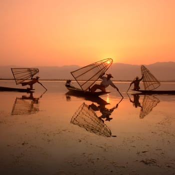 Fishermen at sunrise in the Landscape on the Inle Lake in the Shan State in the east of Myanmar in Southeastasia.