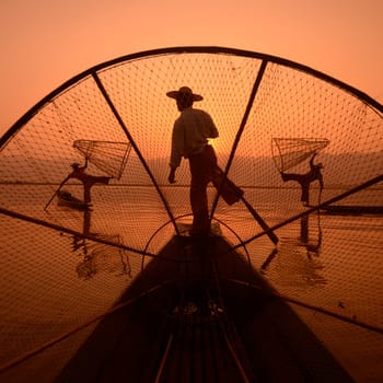 Fishermen at sunrise in the Landscape on the Inle Lake in the Shan State in the east of Myanmar in Southeastasia.
