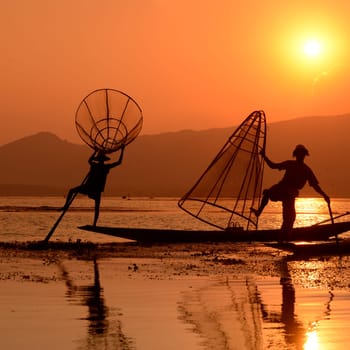 Fishermen at sunset in the Landscape on the Inle Lake in the Shan State in the east of Myanmar in Southeastasia.