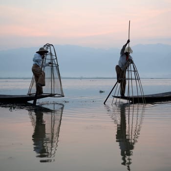 Fishermen at sunrise in the Landscape on the Inle Lake in the Shan State in the east of Myanmar in Southeastasia.