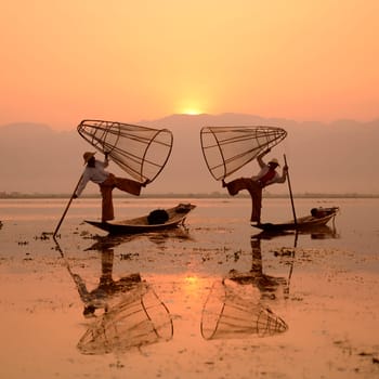 Fishermen at sunrise in the Landscape on the Inle Lake in the Shan State in the east of Myanmar in Southeastasia.