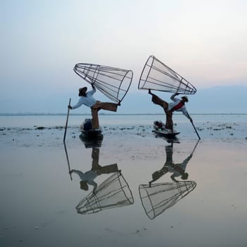 Fishermen at sunrise in the Landscape on the Inle Lake in the Shan State in the east of Myanmar in Southeastasia.